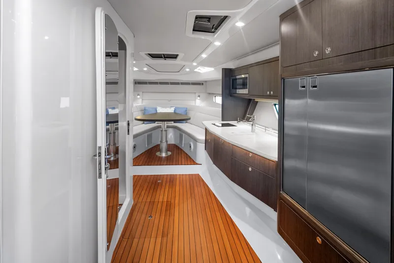  Yacht Photos Pics Luxurious interior of 2024 Intrepid 477 Evolution yacht with modern kitchen and seating area.
