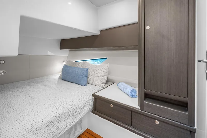  Yacht Photos Pics Luxurious cabin interior of 2024 Intrepid 477 Evolution yacht with cozy bedding and storage.