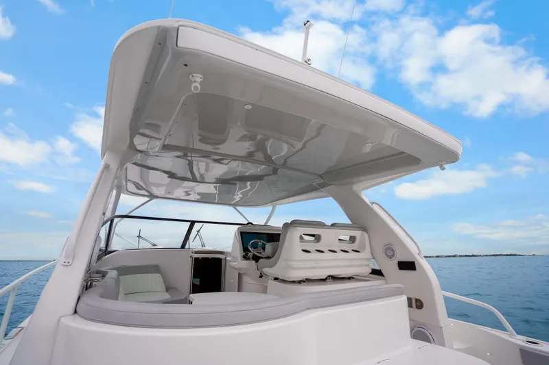  Yacht Photos Pics 2024 Intrepid 477 Evolution yacht with sleek design and spacious deck under blue sky.