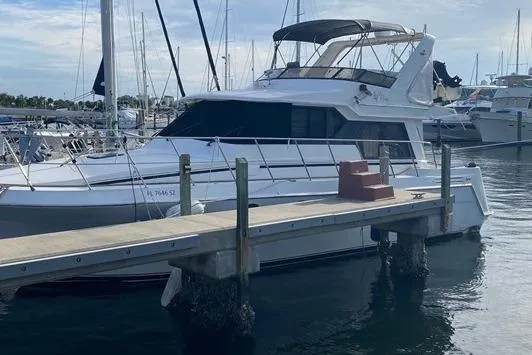 Thistle Do Nicely Yacht Photos Pics 1997 Navigator 4200 yacht docked at marina, featuring sleek white design and spacious upper deck.