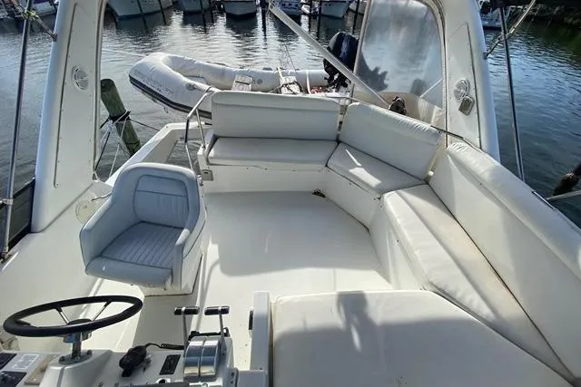 Thistle Do Nicely Yacht Photos Pics Cockpit view of 1997 Navigator 4200 yacht with white seating and steering wheel.