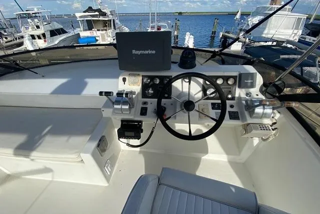 Thistle Do Nicely Yacht Photos Pics Cockpit of 1997 Navigator 4200 yacht with steering wheel and Raymarine navigation system.
