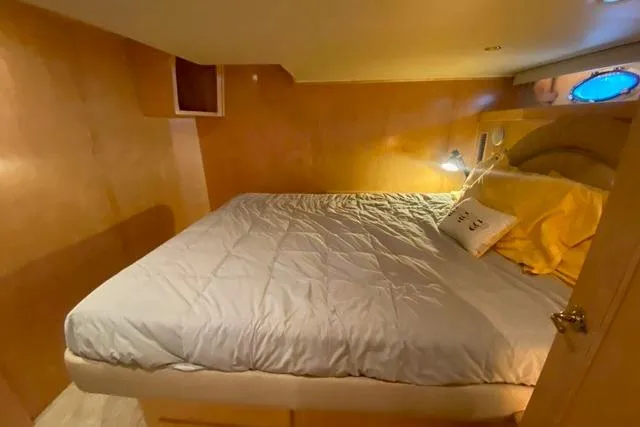 Thistle Do Nicely Yacht Photos Pics Cozy bedroom in 1997 Navigator 4200 yacht with wood paneling and porthole window.