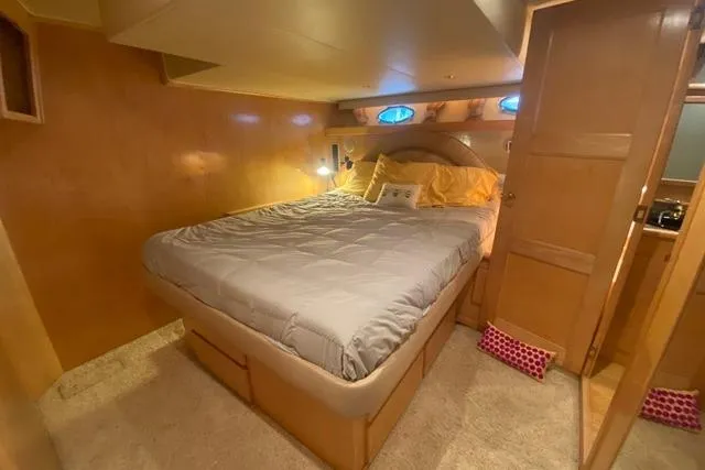 Thistle Do Nicely Yacht Photos Pics Cozy bedroom in 1997 Navigator 4200 yacht with wood paneling and plush bedding.