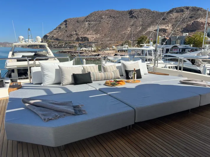 Ganesha Yacht Photos Pics Luxurious Azimut 98 Leonardo yacht deck with sun loungers, cushions, and scenic marina view.