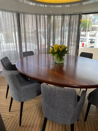 Ganesha Yacht Photos Pics Luxurious dining area on 2003 Azimut 98 Leonardo yacht with elegant table and chairs.