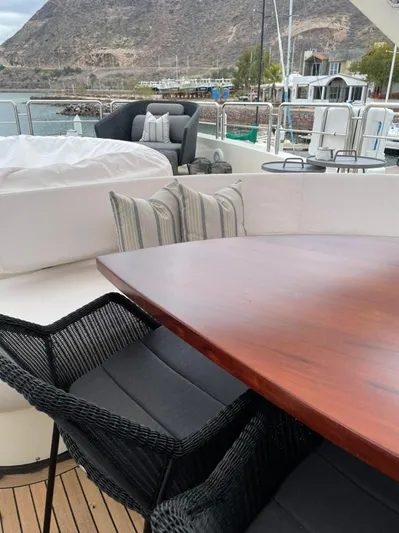 Ganesha Yacht Photos Pics Luxury yacht deck with elegant seating, wooden table, and scenic coastal view. Azimut 98 Leonardo, 2003.