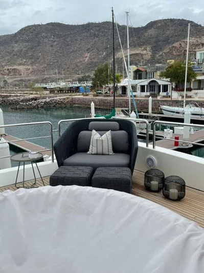 Ganesha Yacht Photos Pics Luxury seating on 2003 Azimut 98 Leonardo yacht, docked with scenic mountain backdrop.