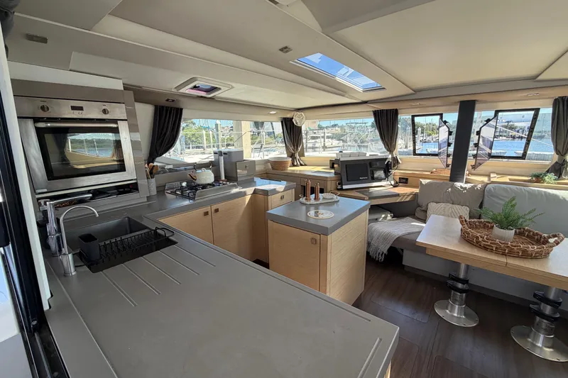 Waymaker Yacht Photos Pics Luxurious interior of 2018 Fountaine Pajot Saona 47 catamaran with modern kitchen and seating area.