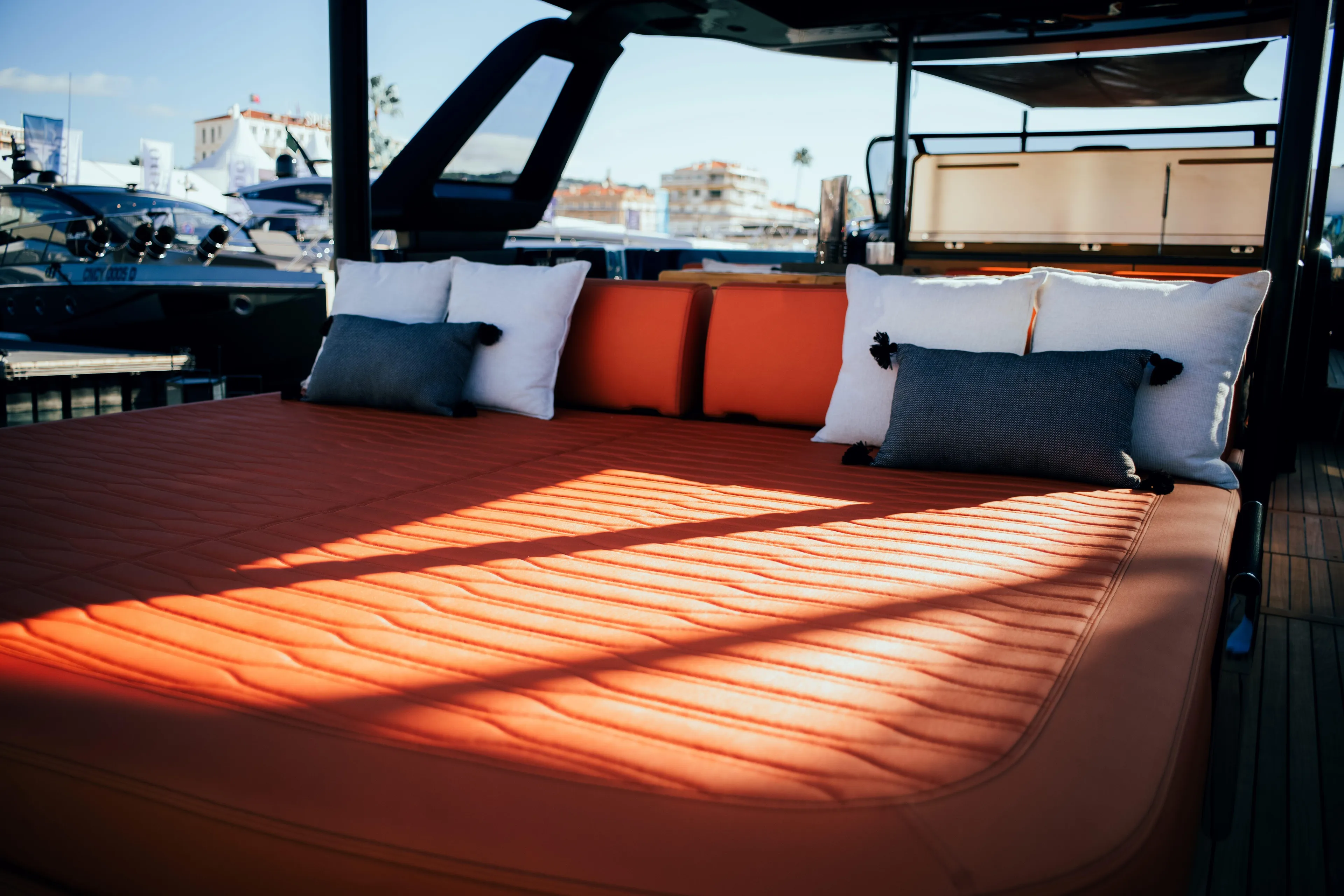  Yacht Photos Pics Luxurious sunbed on 2025 Cranchi A46 Luxury Tender yacht, featuring orange cushions and pillows.