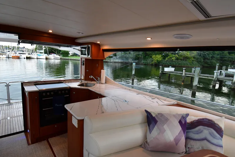 Promesa Yacht Photos Pics Interior view of 2021 Hylas M44 yacht with modern kitchen and scenic marina backdrop.