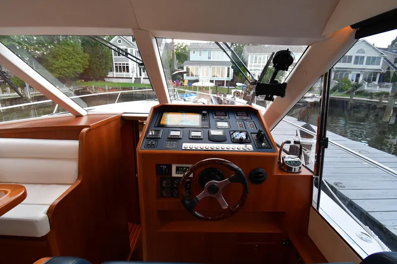 Promesa Yacht Photos Pics Interior view of 2021 Hylas M44 yacht helm with modern controls and waterfront background.
