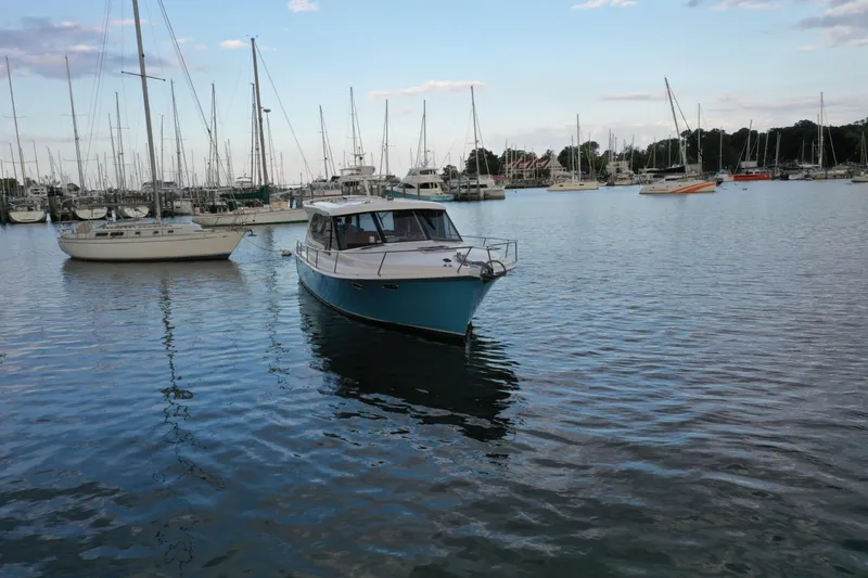 Promesa Yacht Photos Pics 2021 Hylas M44 yacht in a marina with sailboats and calm water.