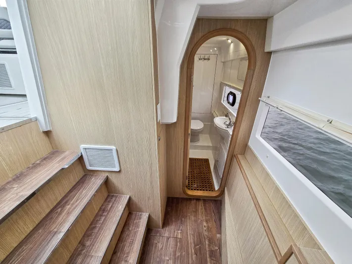 Calypso Yacht Photos Pics Interior of 2020 Aquila 36 Sport yacht, featuring wooden stairs and a compact bathroom.