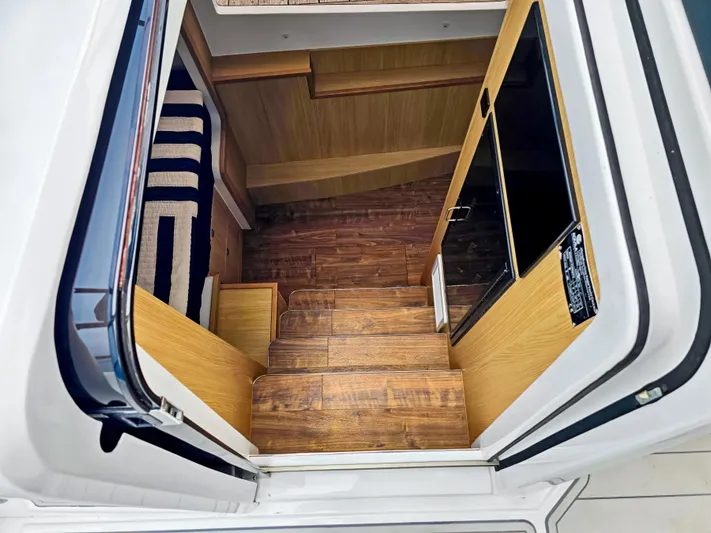 Calypso Yacht Photos Pics Interior view of 2020 Aquila 36 Sport yacht, featuring wooden stairs and modern design.