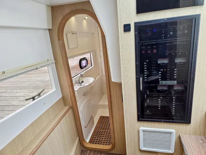 Calypso Yacht Photos Pics Interior of 2020 Aquila 36 Sport yacht, featuring a compact bathroom and control panel.