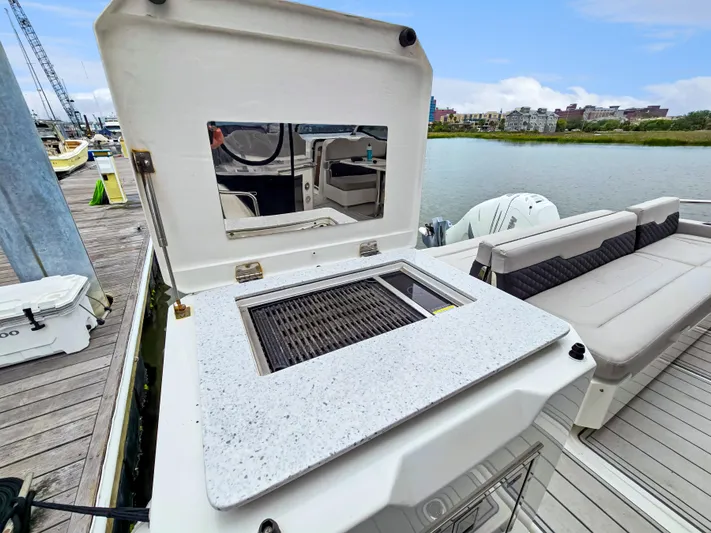 Calypso Yacht Photos Pics Aquila 36 Sport 2020 boat with outdoor grill and seating area on a dock.