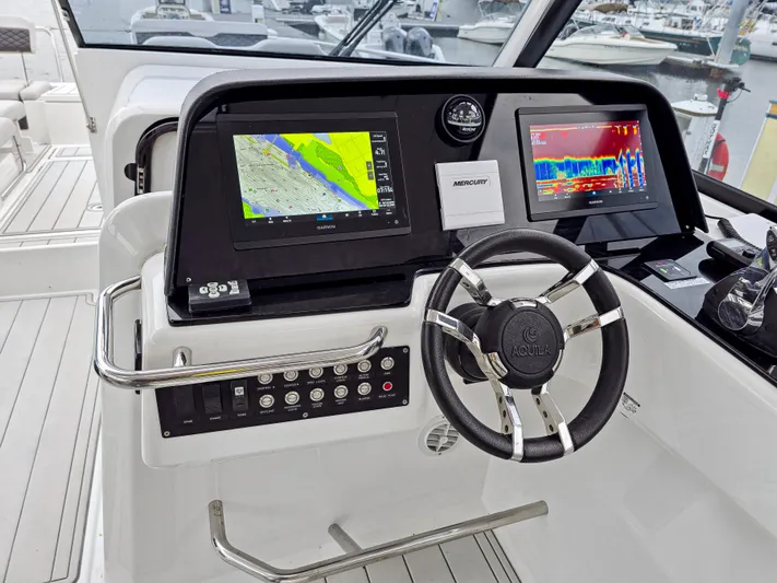 Calypso Yacht Photos Pics Helm of 2020 Aquila 36 Sport with navigation screens and steering wheel.