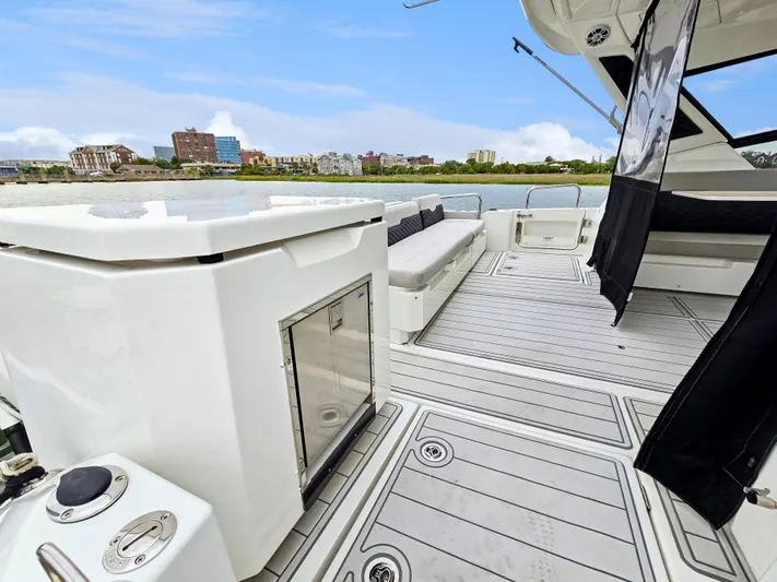 Calypso Yacht Photos Pics Aquila 36 Sport 2020 yacht deck with seating, cityscape in background.