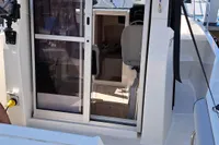2022 Quicksilver 705 Pilothouse boat with open sliding door, docked at marina.