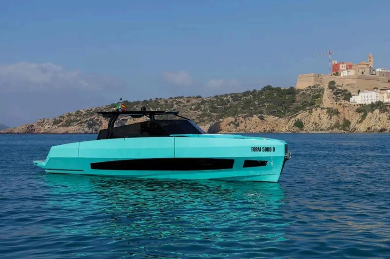  Yacht Photos Pics Turquoise 2024 Suerte 50 yacht on calm sea near rocky coastline.