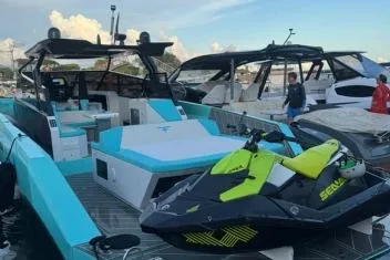  Yacht Photos Pics 2024 Suerte 50 yacht with a jet ski on deck, docked at a marina.