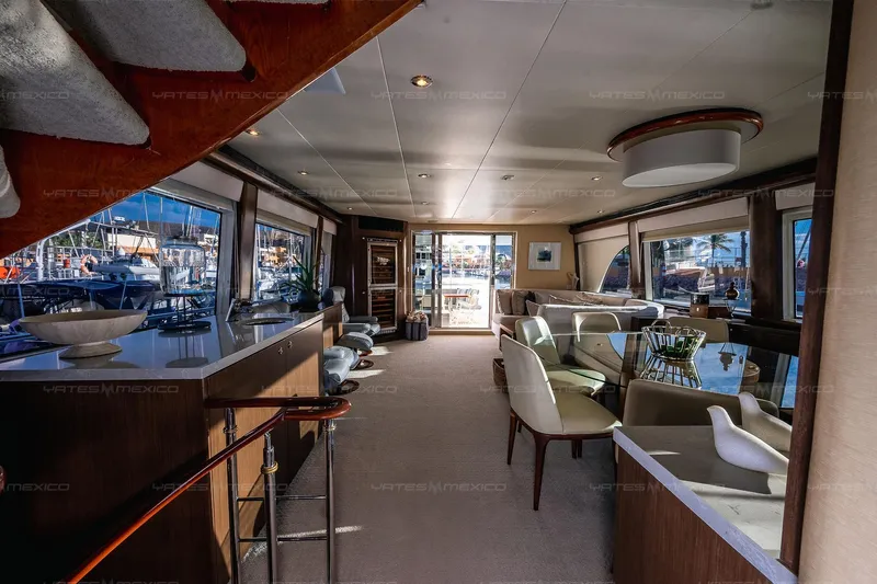 Mijito Yacht Photos Pics Luxurious interior of a 2002 Bravo 82 yacht, featuring elegant seating and large windows.