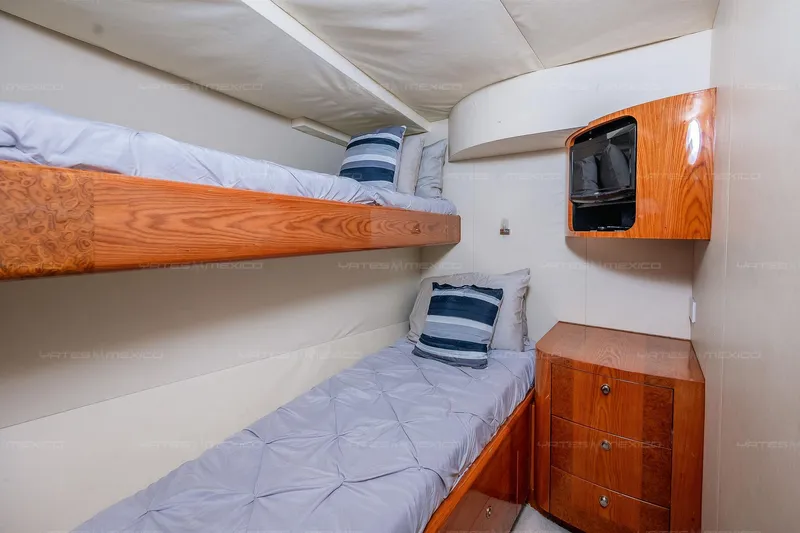 Mijito Yacht Photos Pics Cozy cabin with wooden bunk beds and storage on a 2002 Bravo 82 yacht.