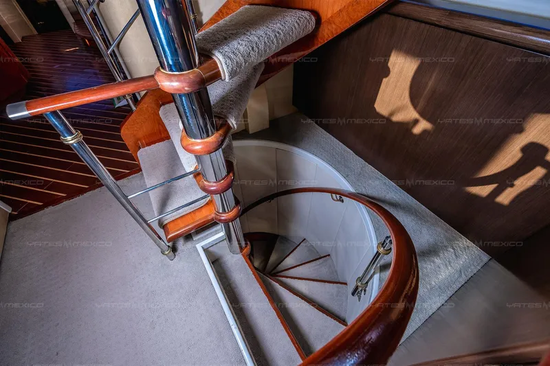 Mijito Yacht Photos Pics Spiral staircase with wooden handrails inside a 2002 Bravo 82 yacht.