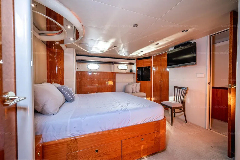 Mijito Yacht Photos Pics Luxurious bedroom interior on 2002 Bravo 82 yacht, featuring wood paneling and modern amenities.