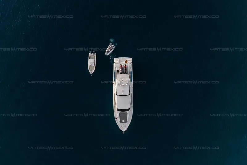 Mijito Yacht Photos Pics Aerial view of Bravo 82 yacht with two smaller boats, 2002 model, in deep blue sea.