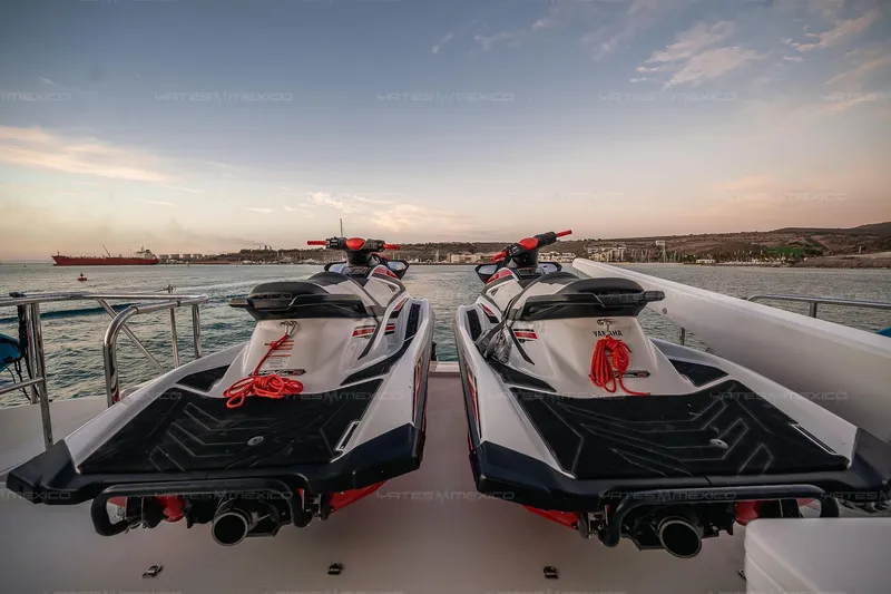 Mijito Yacht Photos Pics Two jet skis on a boat deck at sunset, Bravo 82 model, 2002.