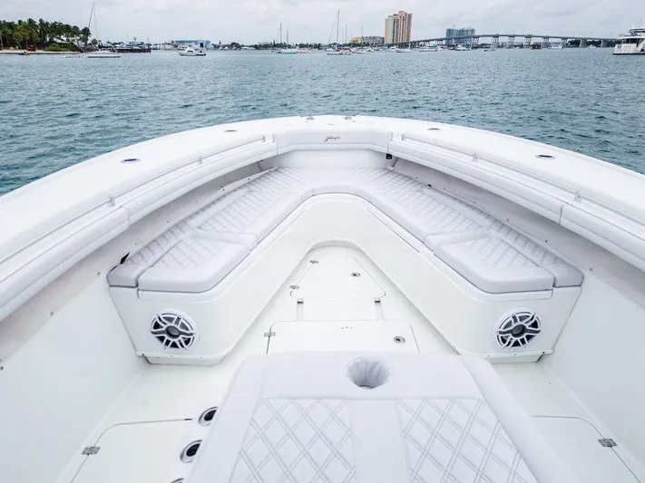  Yacht Photos Pics 2019 Yellowfin 42 boat with spacious seating, on calm waters, near a city skyline.