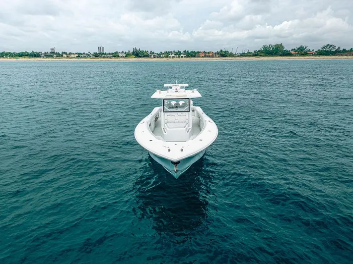  Yacht Photos Pics 2019 Yellowfin 42 boat on calm ocean near coastline under cloudy sky.