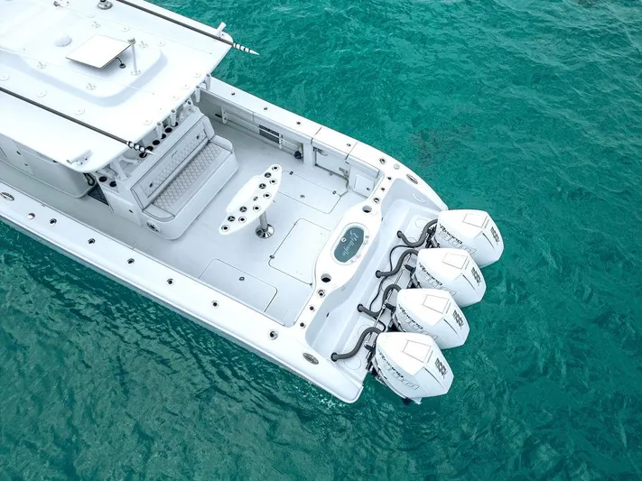  Yacht Photos Pics 2019 Yellowfin 42 boat with triple outboard engines on clear turquoise water.