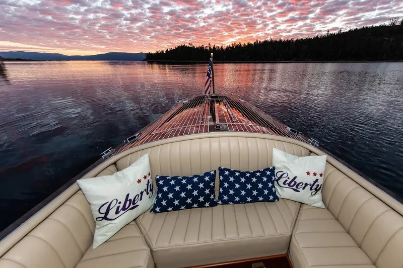 Liberty 1776 Yacht Photos Pics 2007 Hacker-Craft 32 Sportabout boat at sunset with patriotic pillows and serene lake view.