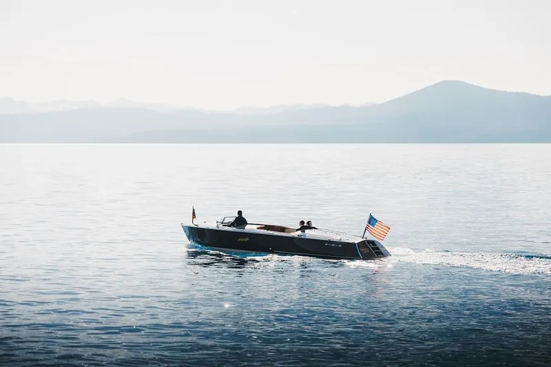 Liberty 1776 Yacht Photos Pics 2007 Hacker-Craft 32 Sportabout cruising on a serene lake with mountains in the background.