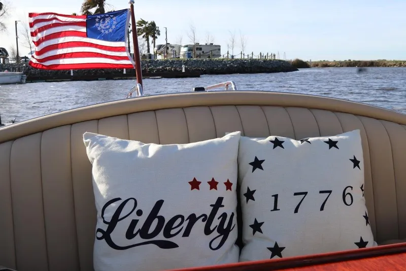Liberty 1776 Yacht Photos Pics 2007 Hacker-Craft 32 Sportabout with patriotic pillows and American flag on a sunny day.