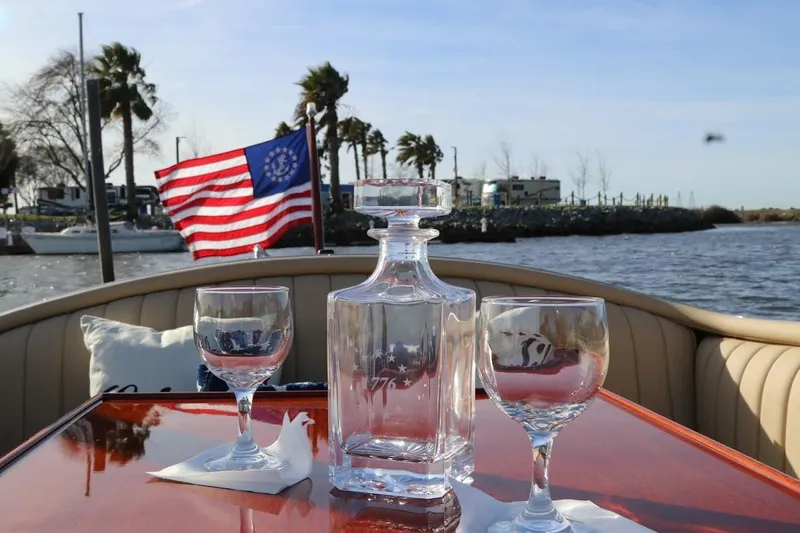 Liberty 1776 Yacht Photos Pics 2007 Hacker-Craft 32 Sportabout with glassware and American flag on a sunny day.