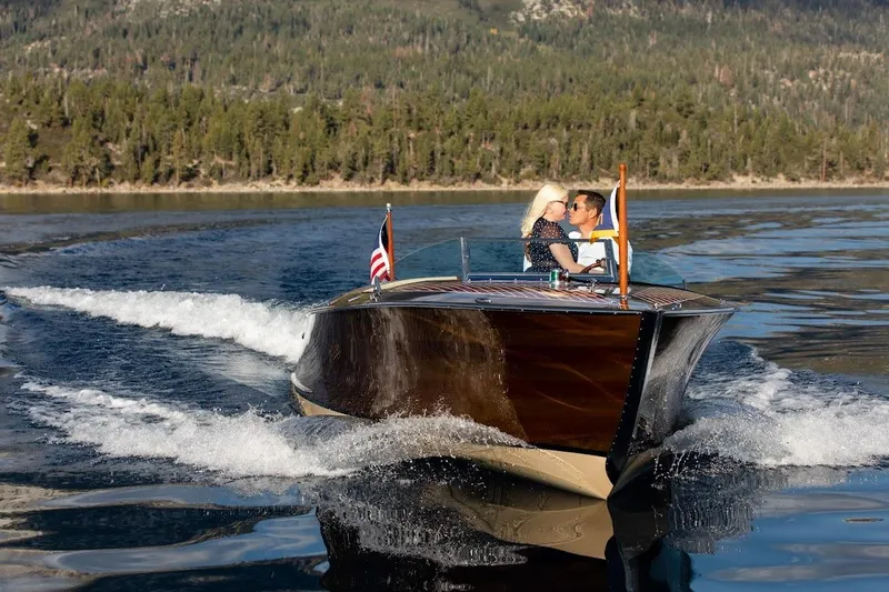 Liberty 1776 Yacht Photos Pics 2007 Hacker-Craft 32 Sportabout cruising on a scenic lake with a couple onboard.