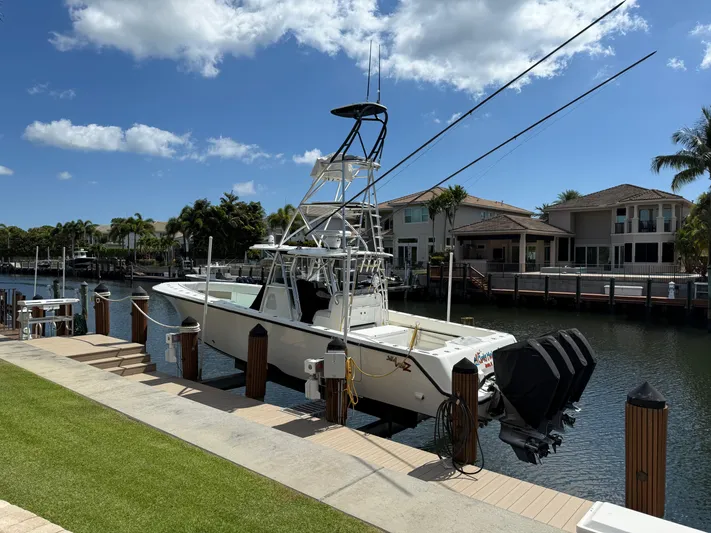  Yacht Photos Pics 2018 SeaVee 390Z boat docked by waterfront homes under a clear blue sky.