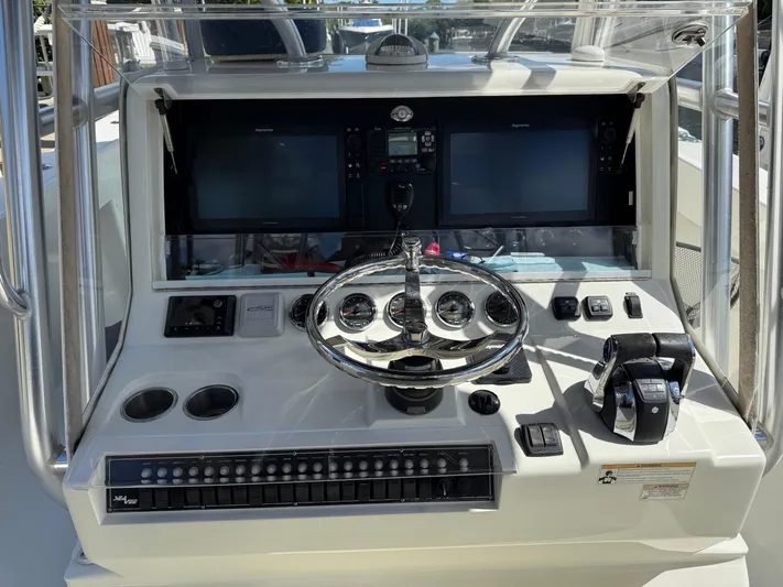  Yacht Photos Pics Control panel of a 2018 SeaVee 390Z boat with steering wheel and navigation screens.
