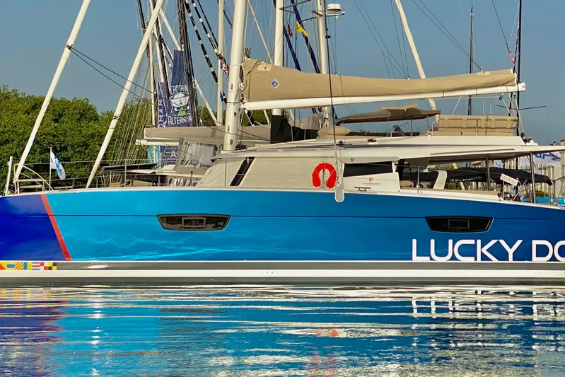 Lucky Dog Yacht Photos Pics 2022 Fountaine Pajot Tanna 47 catamaran, blue hull, docked at marina.