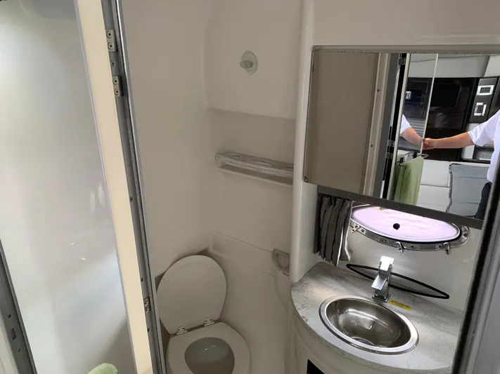 The Great Escape Yacht Photos Pics 2017 Formula 34 Cruiser bathroom with toilet, sink, and mirror.