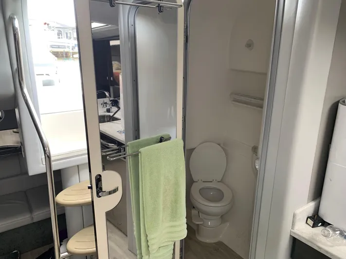 The Great Escape Yacht Photos Pics 2017 Formula 34 Cruiser bathroom with toilet, sink, and green towel.