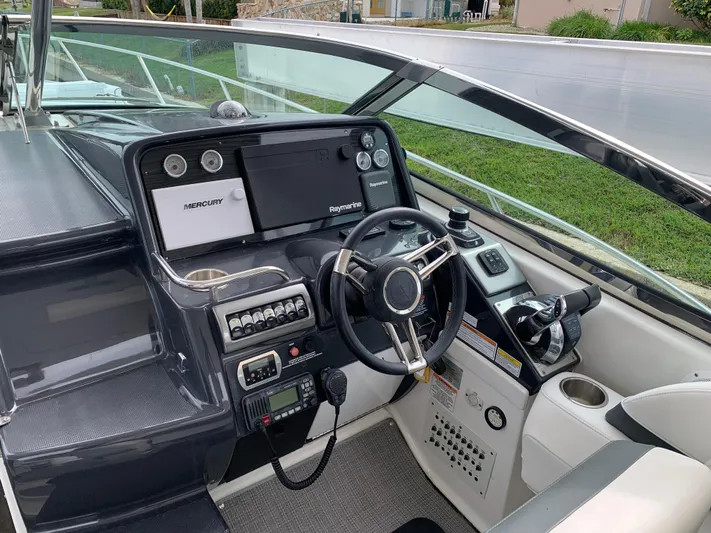 The Great Escape Yacht Photos Pics 2017 Formula 34 Cruiser boat cockpit with steering wheel and control panel.