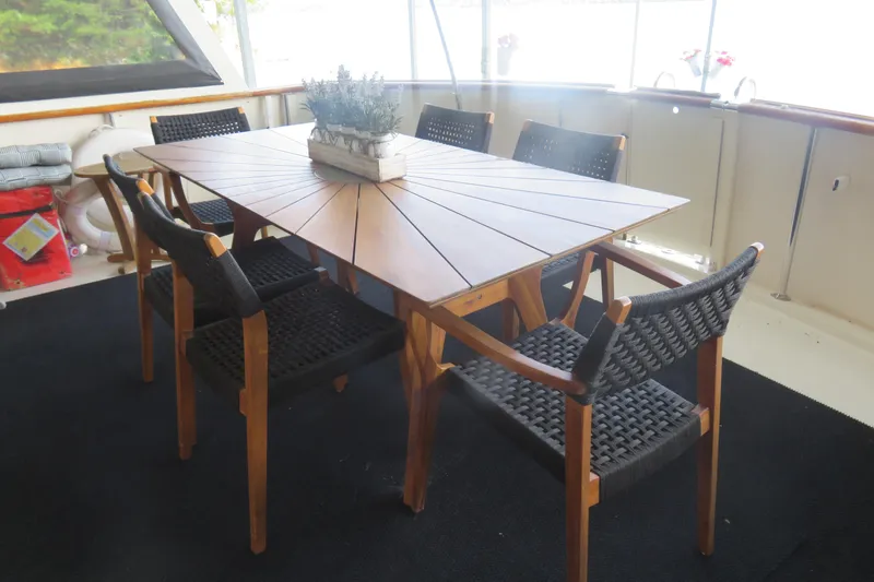 Rive' Gauche Yacht Photos Pics Elegant dining area on 1986 Hatteras 58 Motor Yacht with wooden table and chairs.