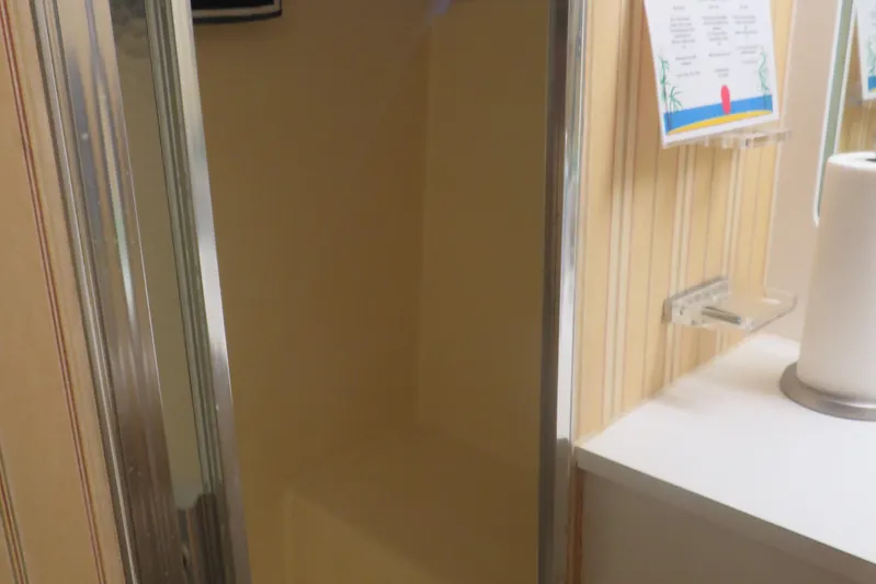 Rive' Gauche Yacht Photos Pics Shower area inside 1986 Hatteras 58 Motor Yacht with striped wallpaper and paper towel holder.