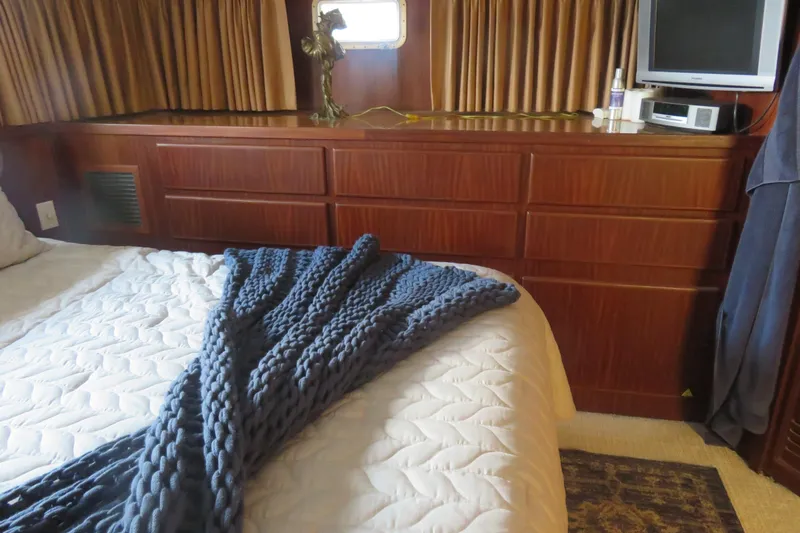 Rive' Gauche Yacht Photos Pics Cozy bedroom in 1986 Hatteras 58 Motor Yacht with wood cabinetry and knit blanket.