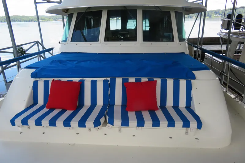 Rive' Gauche Yacht Photos Pics 1986 Hatteras 58 Motor Yacht with blue-striped seating and red cushions on deck.